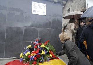 Una mujer deja unas flores ante el osario del cementerio de Moreda donde se depositaron los huesos de Cabacheros.