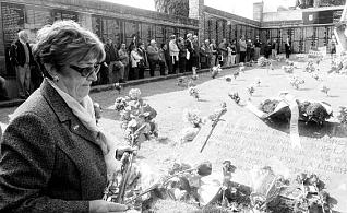 Una mujer, depositando flores, ayer, en la fosa común del  cementerio.