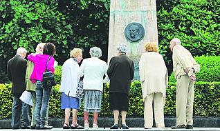 Los presentes, durante el acto conmemorativo delante del medallón  con la efigie de Francisco Franco.